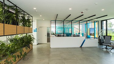 Foto im Innenbereich mit Empfangsbereich und vielen Pflanzen