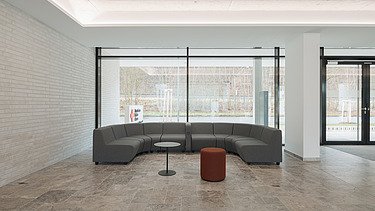 Foto des Innenbereichs des Empfang mit grauem Sofa als Sitzecke