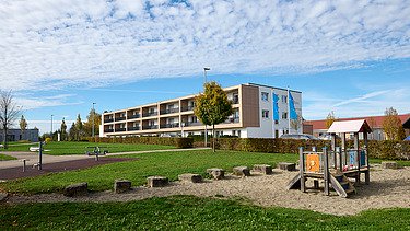 Foto von weiter weg mit Spielplatz im Vordergrund