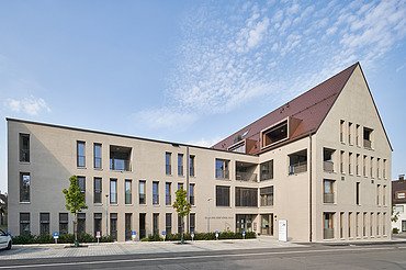 Foto Außenansicht Gebäude mit Eingang und Parkplätzen