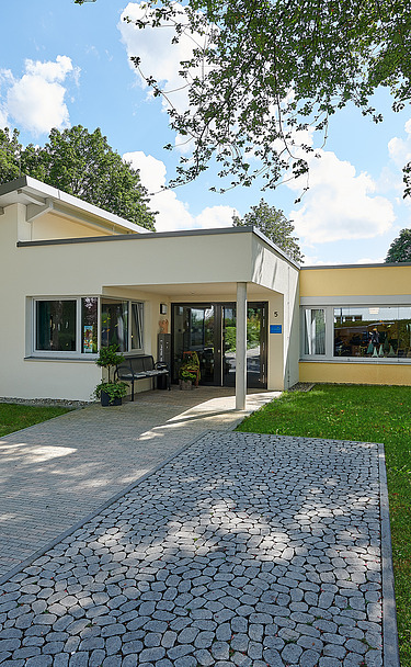 Foto Eingangsbereich mit gepflastertem Weg und grüner Wiese