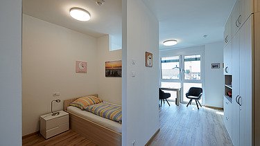 Foto Bewohnerzimmer mit Bett und Stühlen
