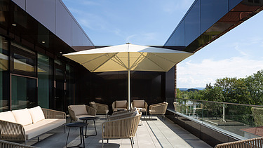 Foto der Dachterasse mit Sonnenschirm und Sonnenmöbeln