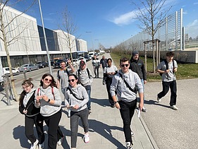 Foto von jungen Menschen, die nebeneinander laufen und gleiche Pullis an ttragen