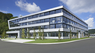 Foto Gebäudeecke mit Außenanlagen bei Sonnenschein