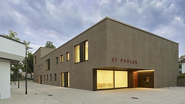 Eckansicht des Gebäudes mit beleuchteten Fenstern