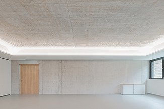 Foto von einem leeren Raum mit Sichtbetonwänden und Sichtbetondecke