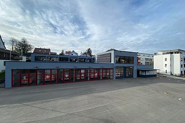 Foto Jugendzentrum von außen mit großem Vorplatz und Bahnschienen an der Seite