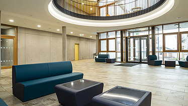 Foto Eingangsbereich mit Sitzbereich, Atrium und Sichtbetonwänden