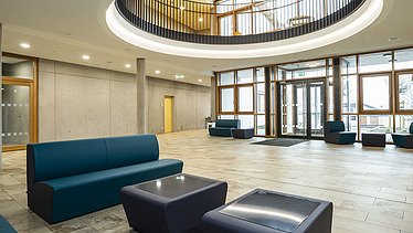 Foto Eingangsbereich mit Sitzbereich, Atrium und Sichtbetonwänden