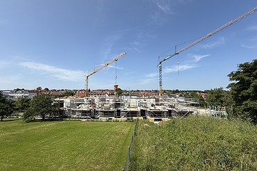 Foto Baustelle von weit weg mit grüner Wiese und blauem Himmel
