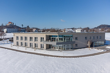 Foto von weit weg und oben mit Gebäudeecke und der Waldburg im Hintergrund